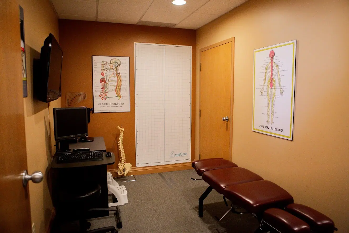 Examination room with an adjustable table and anatomy chart